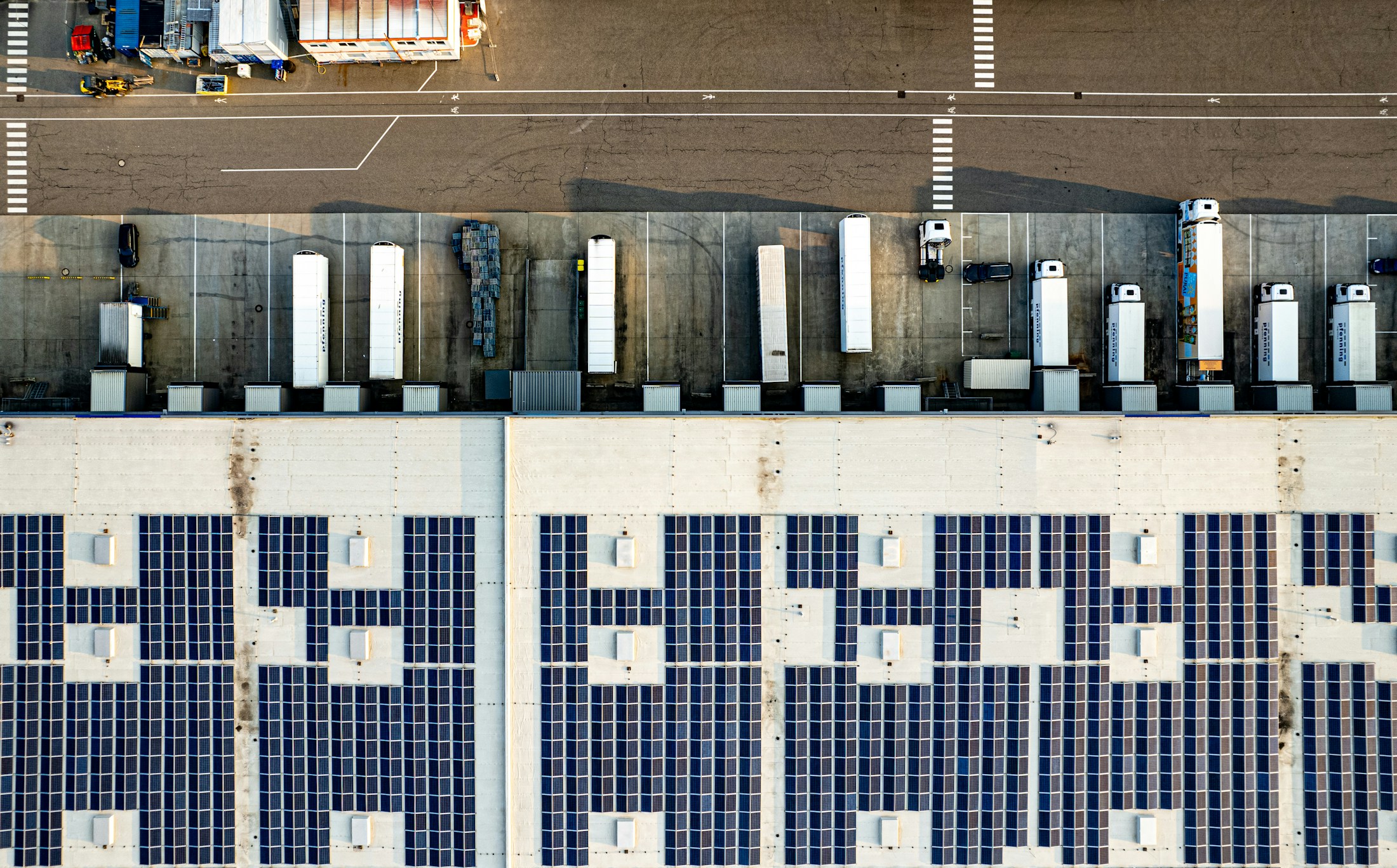 Luftaufnahme einer Industriehalle mit Photovoltaikanlage auf dem Dach